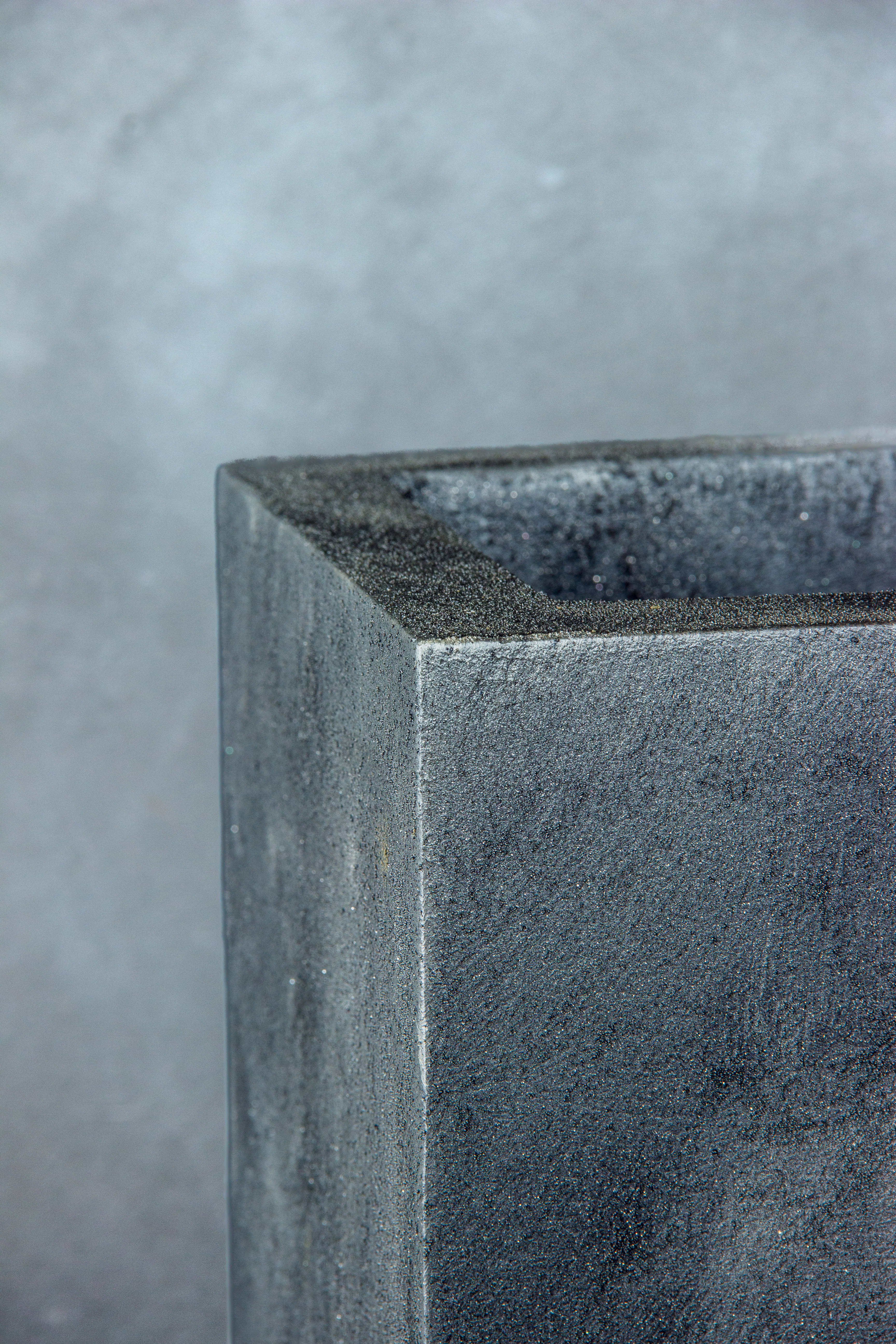 Minimalistyczna szara donica Ferro Verdi Grey LH o strukturze betonu architektonicznego.